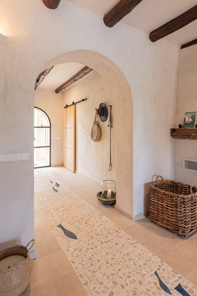 Aménagement d'une porte d'entrée méditerranéenne de taille moyenne avec un mur beige, un sol en travertin, une porte double, une porte en verre, un sol beige et poutres apparentes.