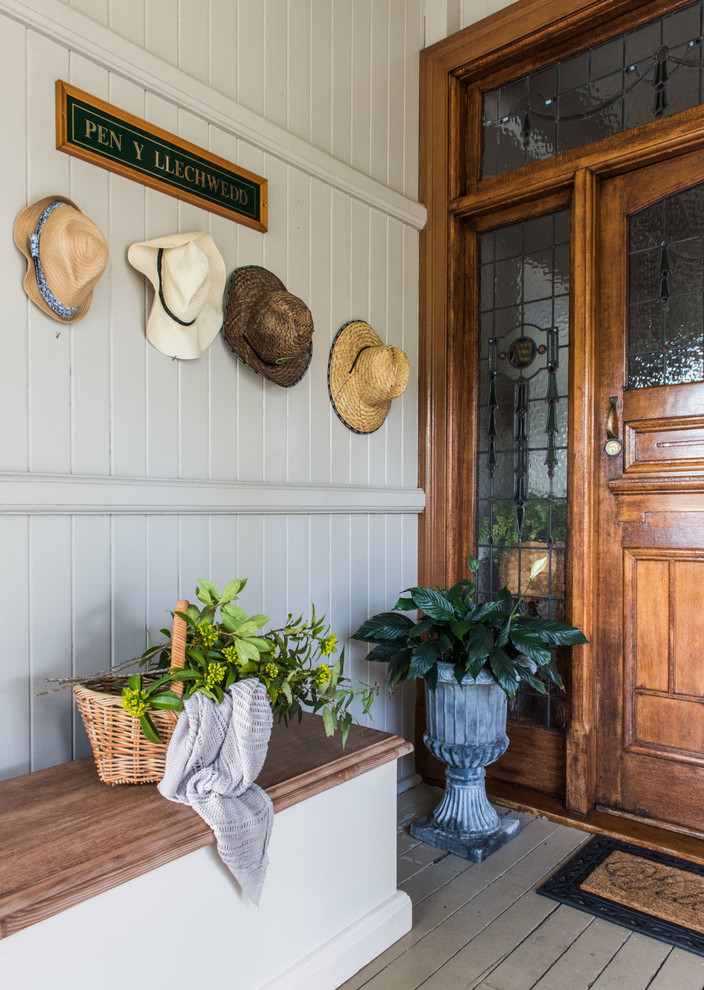 Large country front door in Brisbane with grey walls, painted wood floors, a single front door and a medium wood front door.