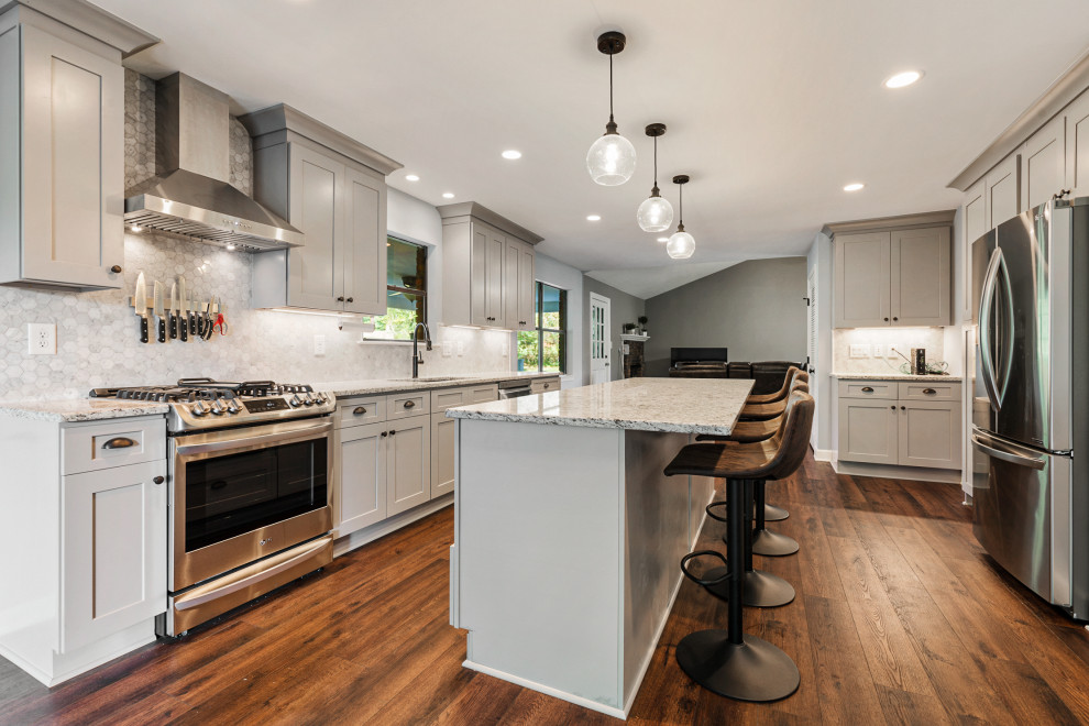 Design ideas for a transitional galley eat-in kitchen in Atlanta with an undermount sink, shaker cabinets, grey cabinets, grey splashback, stainless steel appliances, medium hardwood floors, with island, brown floor and grey benchtop.