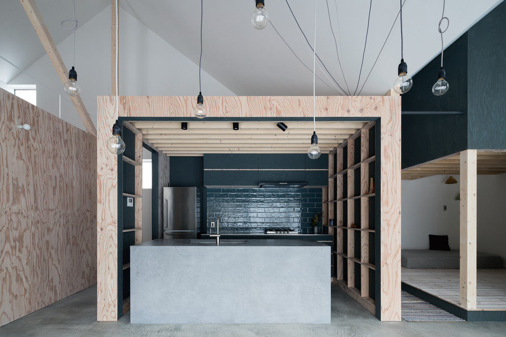 Design ideas for an industrial galley open plan kitchen in Sapporo with an integrated sink, flat-panel cabinets, black cabinets, concrete benchtops, black splashback, concrete floors, with island and grey floor.