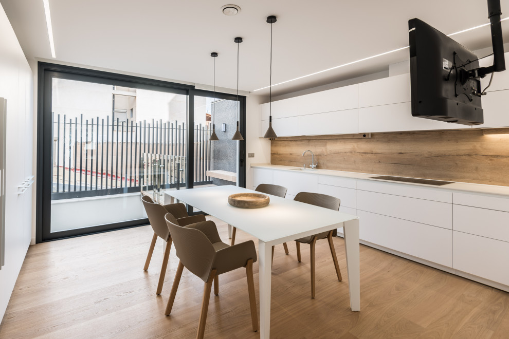 Inspiration for a small contemporary single-wall eat-in kitchen in Alicante-Costa Blanca with an undermount sink, flat-panel cabinets, white cabinets, beige splashback, timber splashback, panelled appliances, no island, beige floor, quartz benchtops, light hardwood floors and white benchtop.