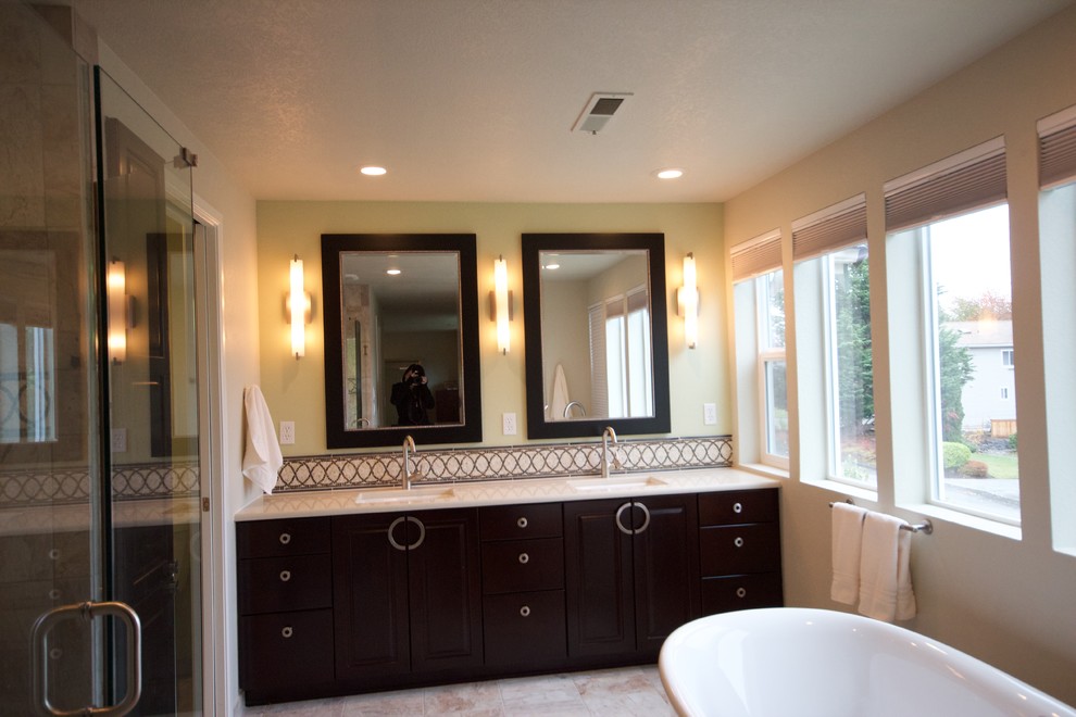 Photo of a master bathroom in Seattle with raised-panel cabinets, dark wood cabinets, a freestanding tub, an alcove shower, ceramic floors, an undermount sink and engineered quartz benchtops.