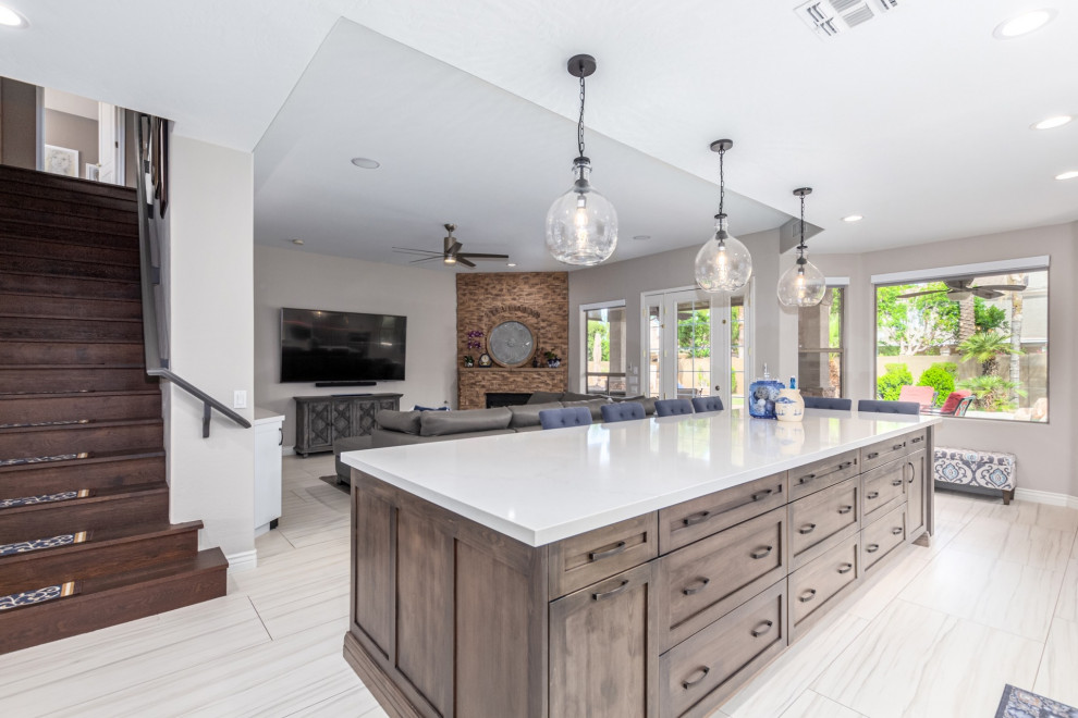 Transitional kitchen photo in Phoenix with a farmhouse sink, shaker cabinets, white cabinets, gray backsplash, stainless steel appliances and white countertops