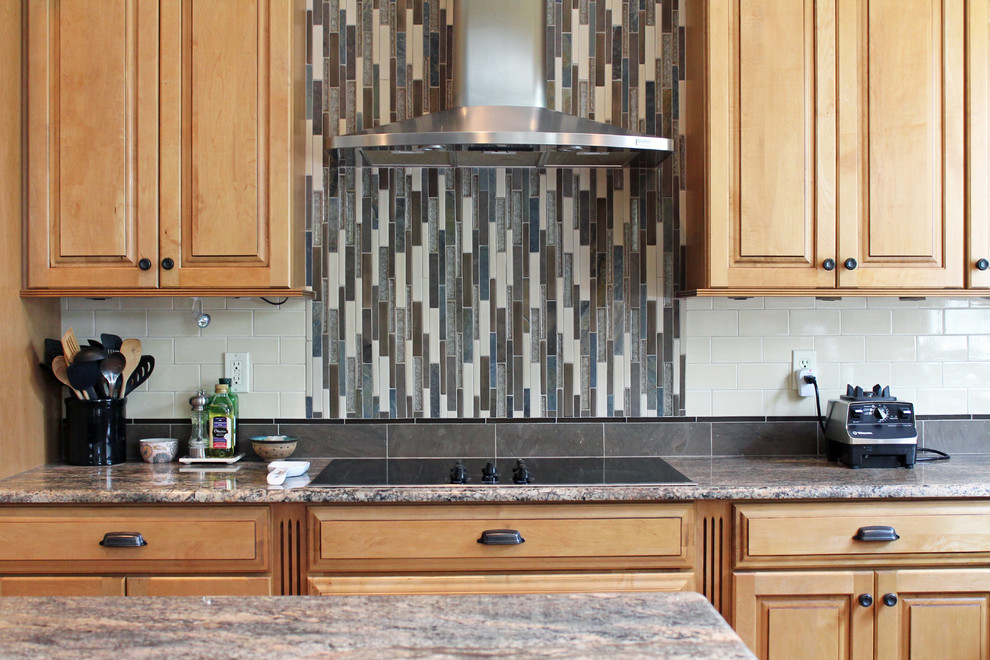 Modelo de cocina comedor clásica con puertas de armario de madera clara, encimera de granito, salpicadero multicolor, salpicadero con mosaicos de azulejos y una isla