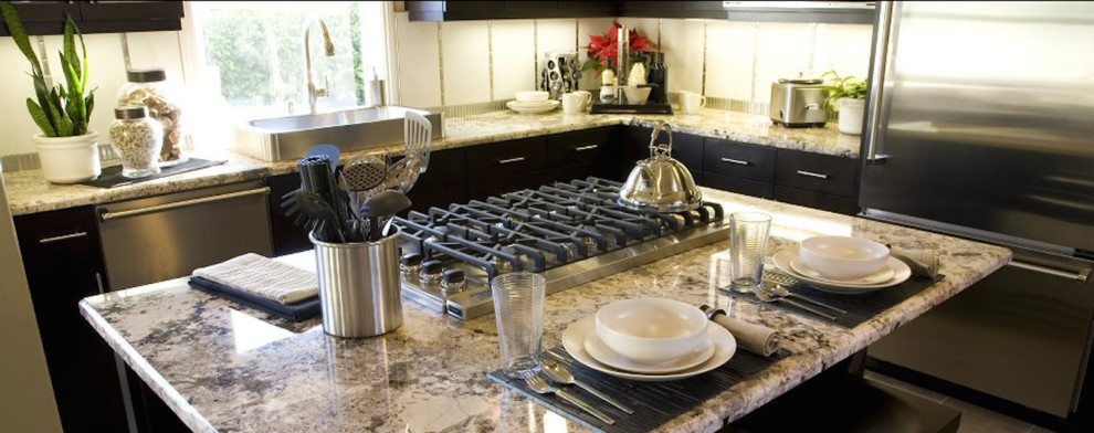 Inspiration for a mid-sized transitional l-shaped kitchen remodel in Minneapolis with a single-bowl sink, flat-panel cabinets, black cabinets, granite countertops, stainless steel appliances and an island