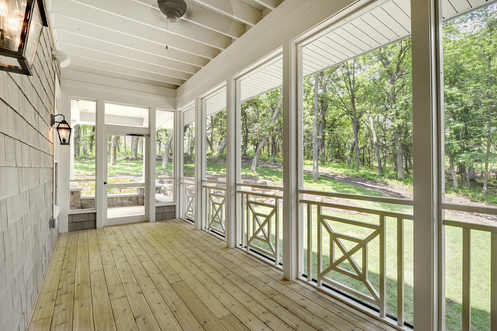 This is an example of a transitional side yard screened-in verandah in Minneapolis with decking and a roof extension.