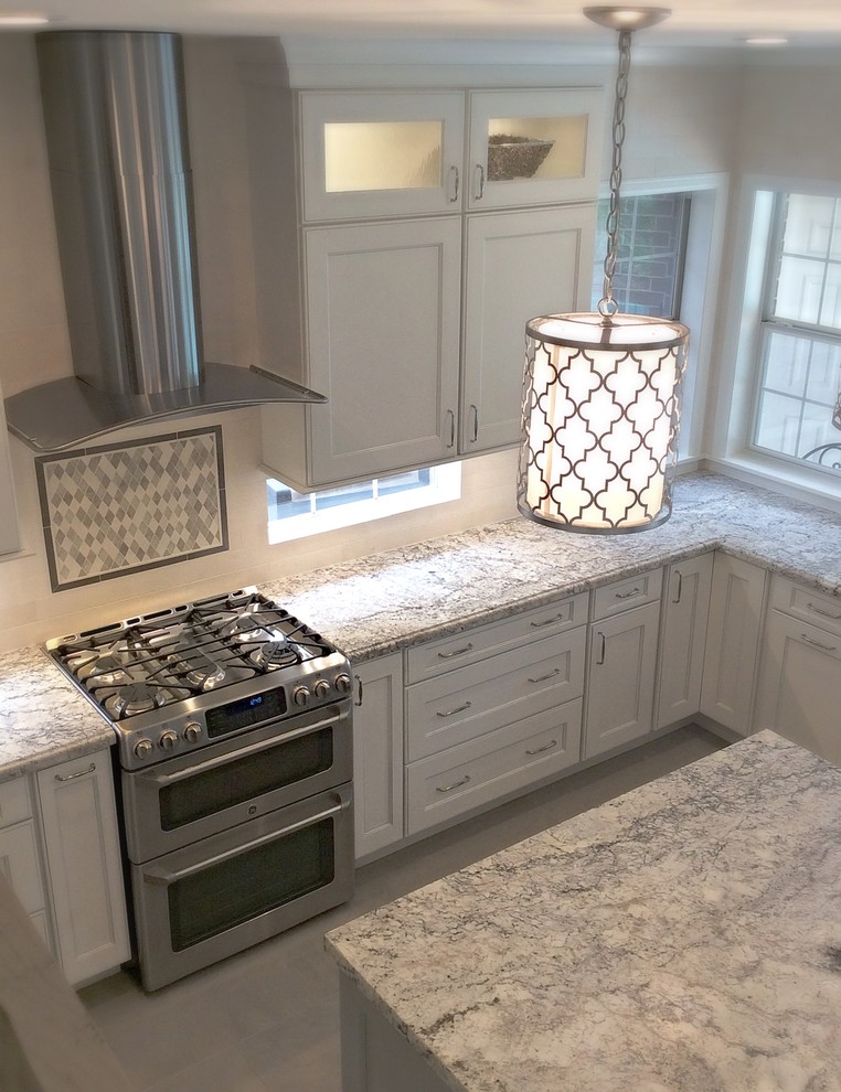 Inspiration for a mid-sized transitional u-shaped ceramic tile eat-in kitchen remodel in Houston with a farmhouse sink, recessed-panel cabinets, white cabinets, granite countertops, white backsplash, stone tile backsplash, stainless steel appliances and an island