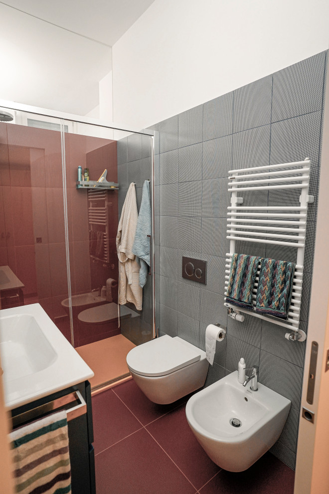 Photo of a mid-sized modern kids bathroom in Milan with blue cabinets, a curbless shower, a two-piece toilet, multi-coloured tile, porcelain tile, white walls, porcelain floors, an integrated sink, red floor, a sliding shower screen, white benchtops, a single vanity and a floating vanity.