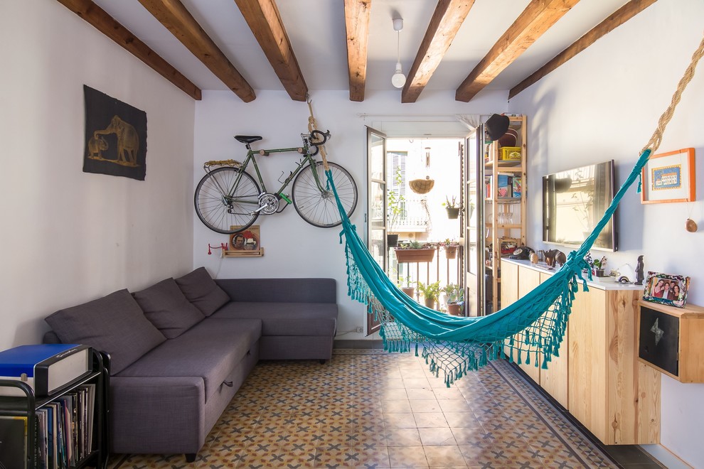 Diseño de sala de estar abierta marinera pequeña con paredes blancas, suelo de baldosas de cerámica, televisor colgado en la pared y suelo multicolor