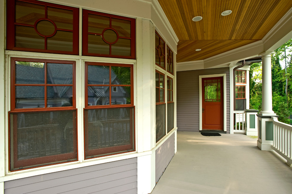 Photo of a mid-sized traditional front yard verandah in New York with concrete slab and a roof extension.