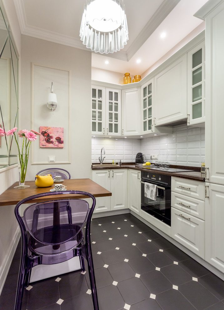 Contemporary l-shaped separate kitchen in Moscow with a drop-in sink, raised-panel cabinets, white cabinets, white splashback, subway tile splashback, black appliances and no island.