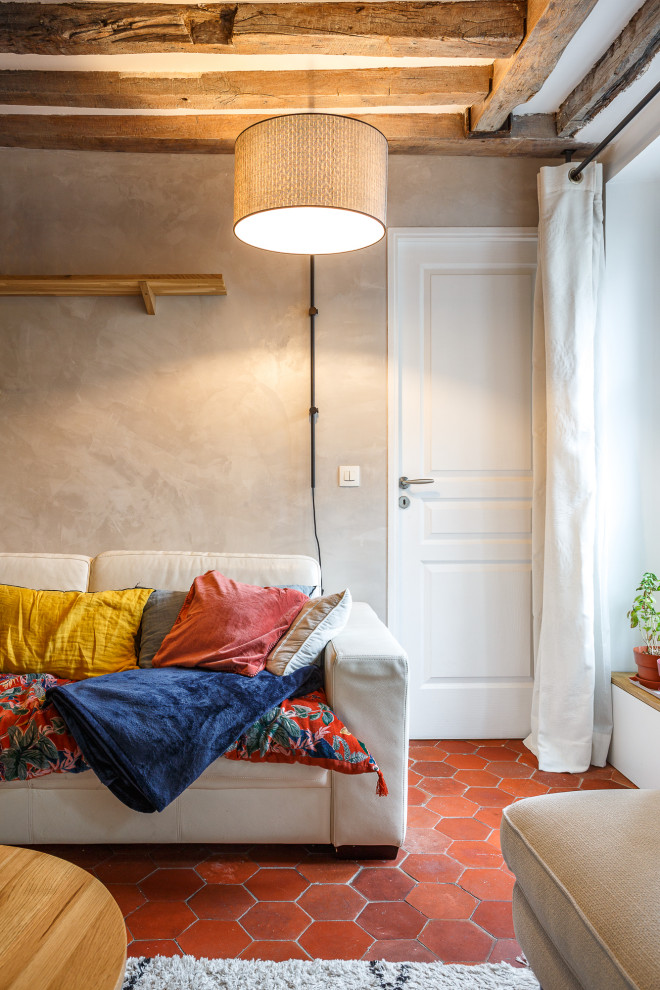 Small contemporary open concept living room in Paris with beige walls, terra-cotta floors, a freestanding tv and orange floor.