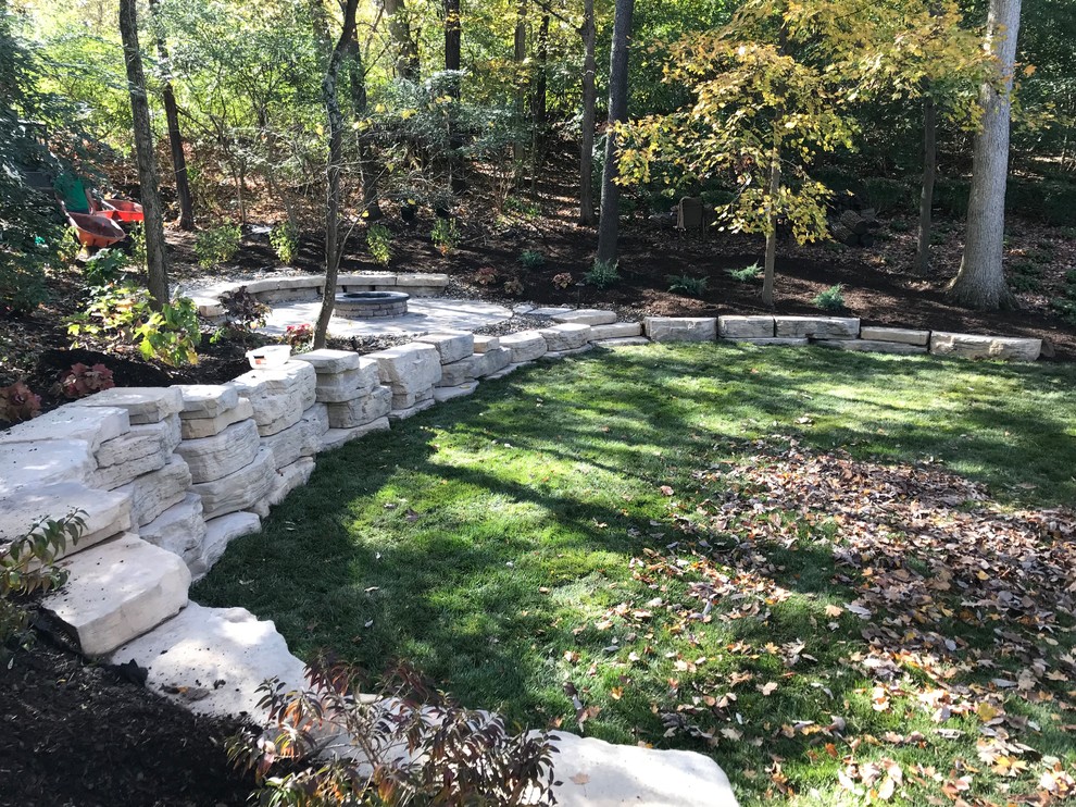 Inspiration for a large rustic shade backyard concrete paver retaining wall landscape for summer.