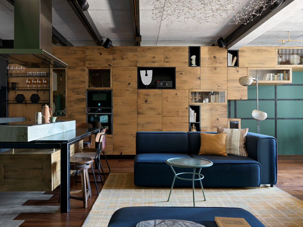 Идея дизайна: открытая гостиная комната среднего размера в стиле лофт с паркетным полом среднего тона, мультимедийным центром, коричневым полом, балками на потолке, синим диваном и зелеными стенами