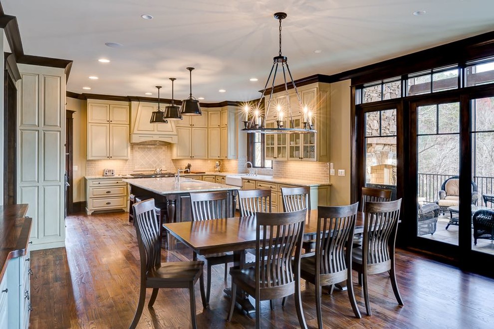 Inspiration for a large arts and crafts u-shaped eat-in kitchen in Atlanta with a farmhouse sink, raised-panel cabinets, beige cabinets, granite benchtops, beige splashback, ceramic splashback, panelled appliances, dark hardwood floors and with island.