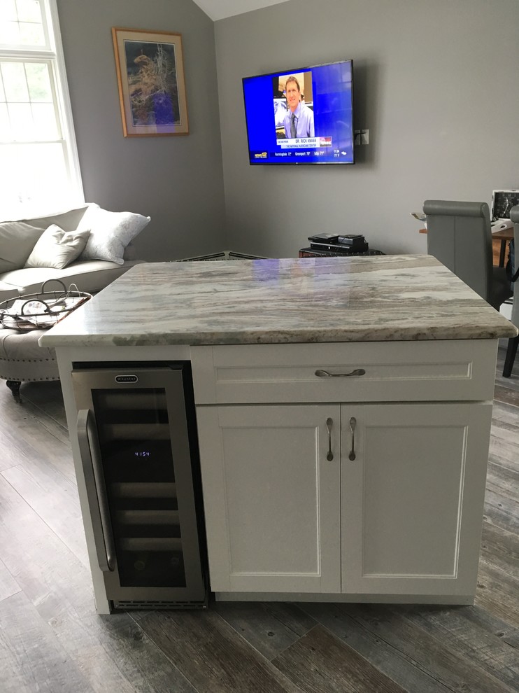 Eat-in kitchen - mid-sized transitional l-shaped medium tone wood floor eat-in kitchen idea with an undermount sink, recessed-panel cabinets, white cabinets, granite countertops, gray backsplash, matchstick tile backsplash, stainless steel appliances and an island