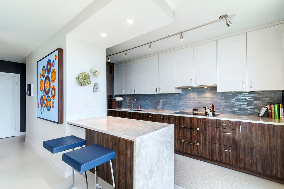 Photo of a small modern galley eat-in kitchen in Chicago with an undermount sink, flat-panel cabinets, medium wood cabinets, quartzite benchtops, white splashback, glass tile splashback, panelled appliances, ceramic floors and a peninsula.