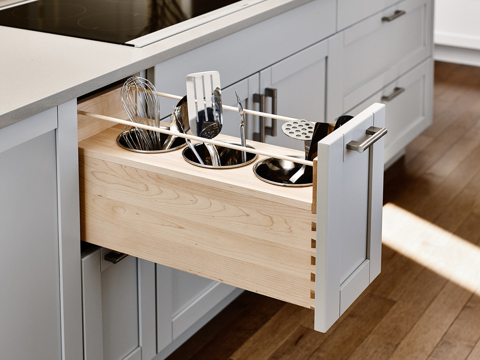 Example of a large transitional u-shaped medium tone wood floor open concept kitchen design with an undermount sink, shaker cabinets, white cabinets, quartz countertops, white backsplash, subway tile backsplash, stainless steel appliances and an island