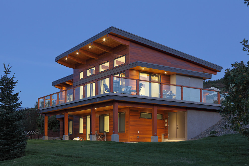 Inspiration for a modern two-storey exterior in Vancouver with wood siding and a flat roof.
