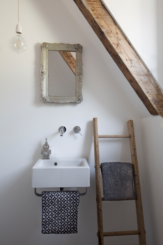 Inspiration pour un WC et toilettes design de taille moyenne avec un mur blanc, sol en béton ciré, un sol gris, un plan de toilette blanc, poutres apparentes, WC séparés et un lavabo suspendu.
