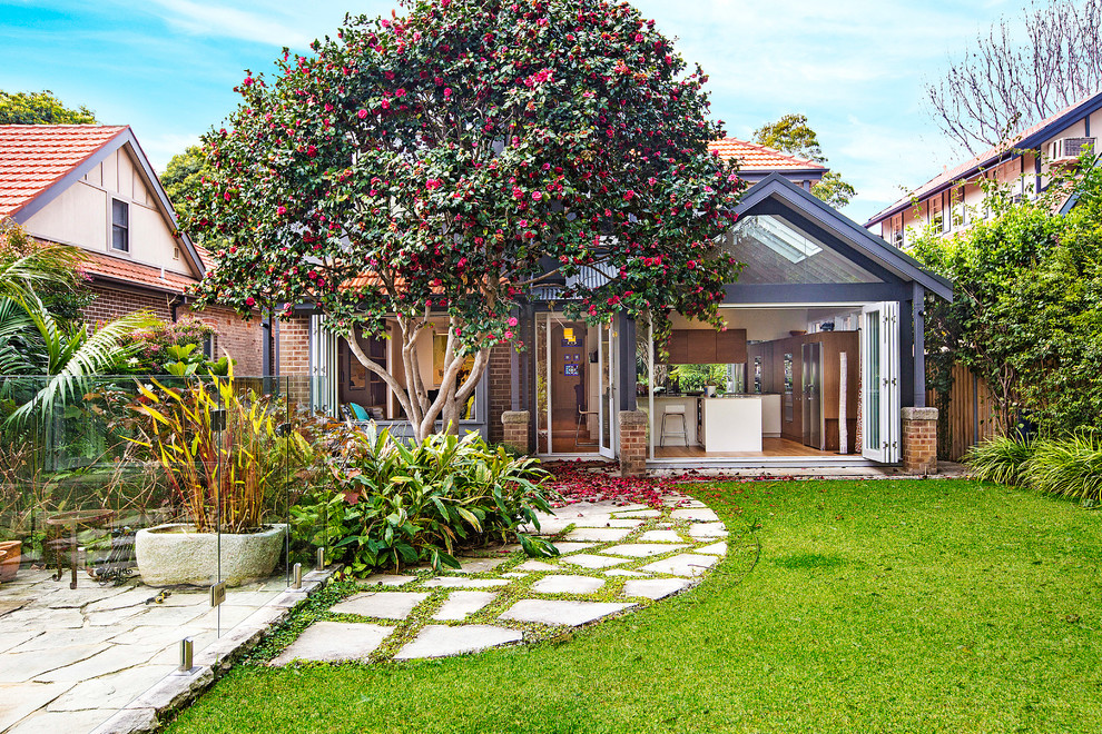 Traditional backyard garden in Sydney with natural stone pavers.