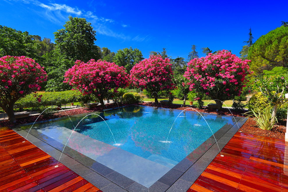 Design ideas for a mid-sized transitional custom-shaped pool in Nice with decking.