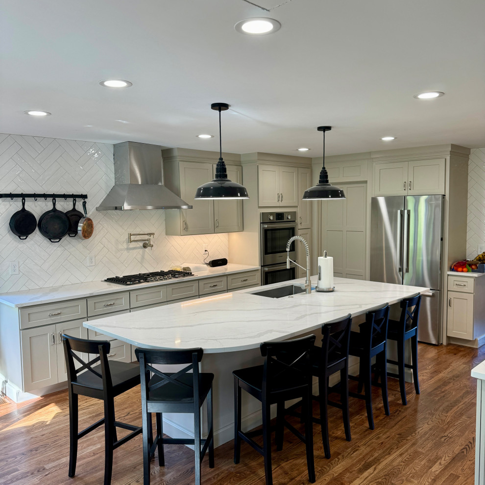 Example of a mid-sized transitional l-shaped medium tone wood floor, brown floor and wallpaper ceiling eat-in kitchen design in Atlanta with an undermount sink, shaker cabinets, white cabinets, granite countertops, white backsplash, stainless steel appliances, an island and white countertops