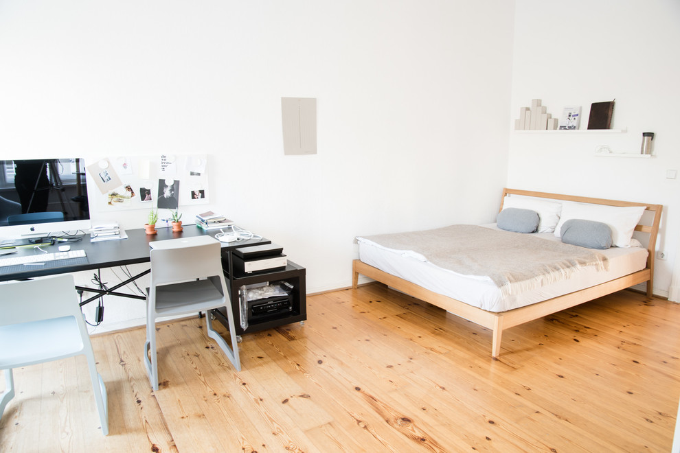 This is an example of a large scandinavian master bedroom in Berlin with white walls, light hardwood floors and no fireplace.