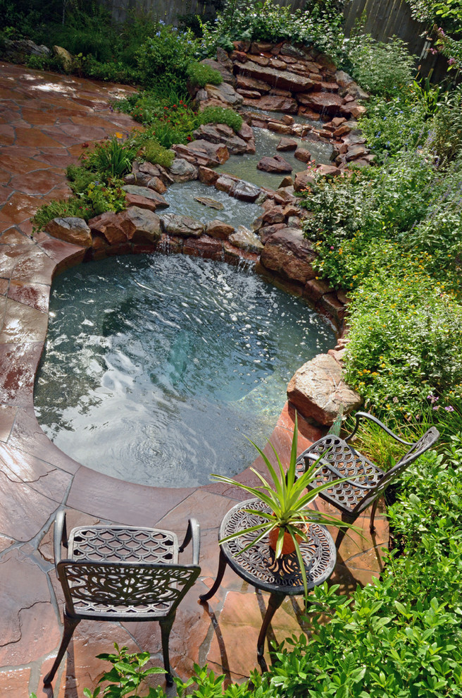 Example of a small mountain style backyard custom-shaped and stone hot tub design in Houston