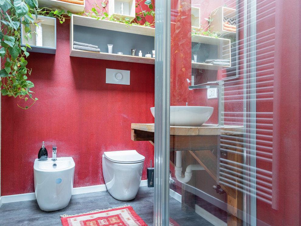Пример оригинального дизайна: туалет среднего размера в стиле модернизм с светлыми деревянными фасадами, красными стенами, полом из винила, настольной раковиной, столешницей из дерева, черным полом, бежевой столешницей и подвесной тумбой