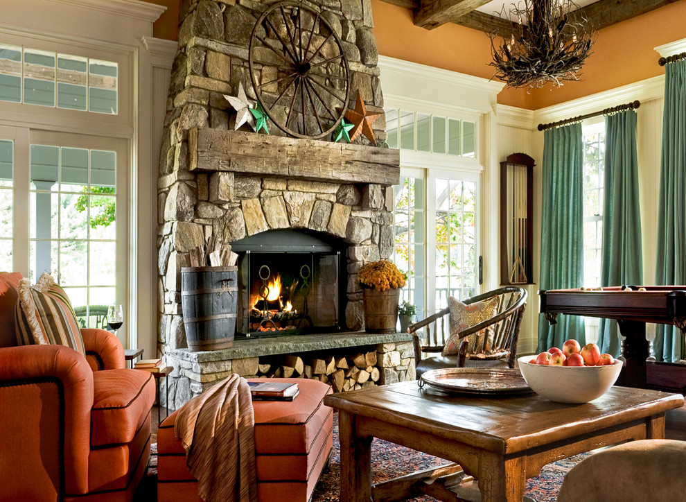 Inspiration for a traditional family room in New York with orange walls and a stone fireplace surround.