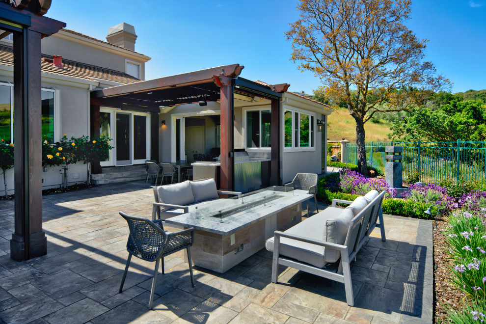 Inspiration for a large mediterranean side patio in San Francisco with an outdoor kitchen, concrete paving and a pergola.