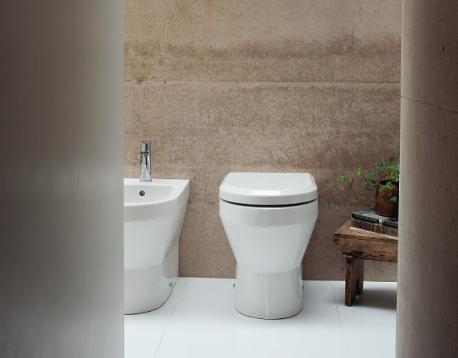 Photo of a mid-sized contemporary kids bathroom in Cambridgeshire with flat-panel cabinets, white cabinets, a drop-in tub, a curbless shower, a one-piece toilet, gray tile, porcelain tile, grey walls, marble floors and a pedestal sink.