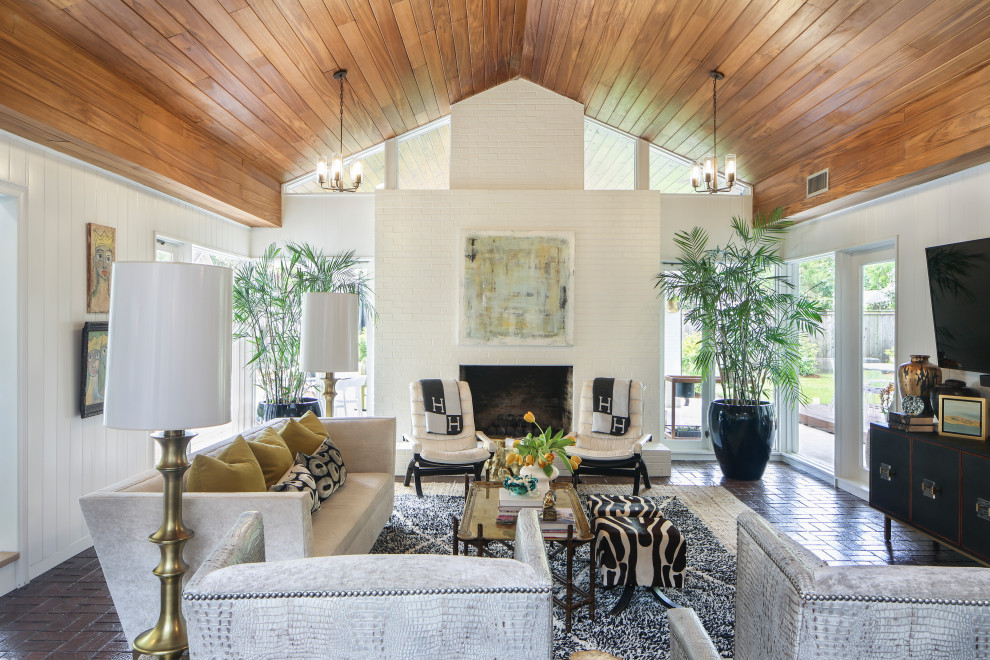 Photo of an expansive midcentury living room in New Orleans with white walls, brick flooring, a standard fireplace, a brick fireplace surround, a wall mounted tv, a wood ceiling and panelled walls.