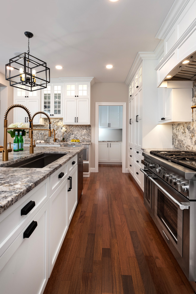 Large transitional u-shaped medium tone wood floor and red floor open concept kitchen photo with an undermount sink, beaded inset cabinets, white cabinets, granite countertops, gray backsplash, granite backsplash, stainless steel appliances, an island and gray countertops