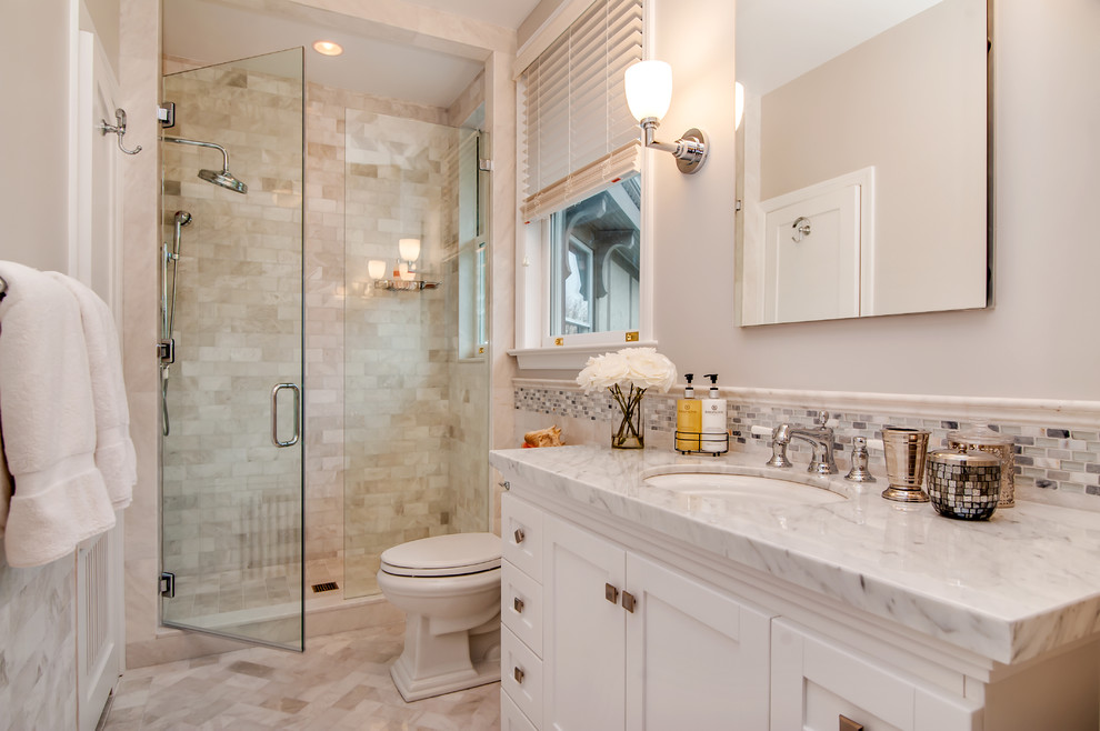 Transitional bathroom in New York with white cabinets, marble floors, an undermount sink, marble benchtops, an alcove shower, beige tile, subway tile and shaker cabinets.