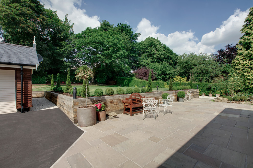 Inspiration for an expansive traditional backyard patio in Other with natural stone pavers.