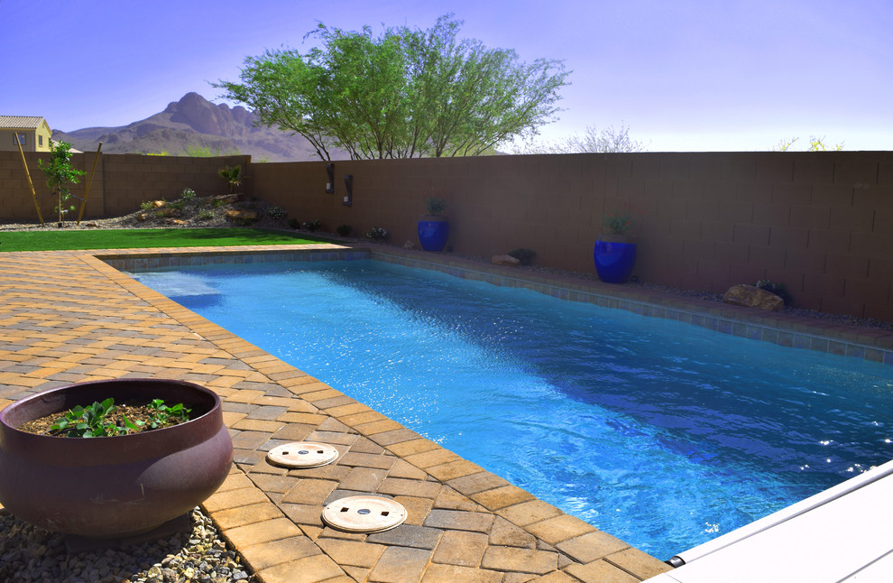 Large backyard concrete paver and rectangular hot tub photo in Phoenix