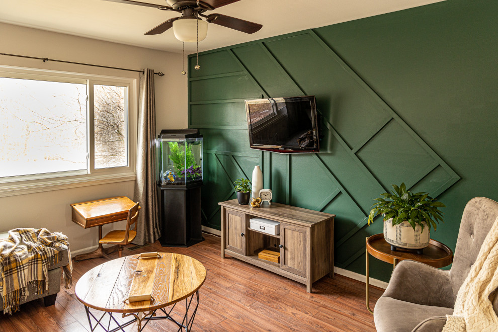 Mid-sized contemporary open concept living room in Detroit with green walls, vinyl floors, no fireplace, a wall-mounted tv, brown floor and panelled walls.