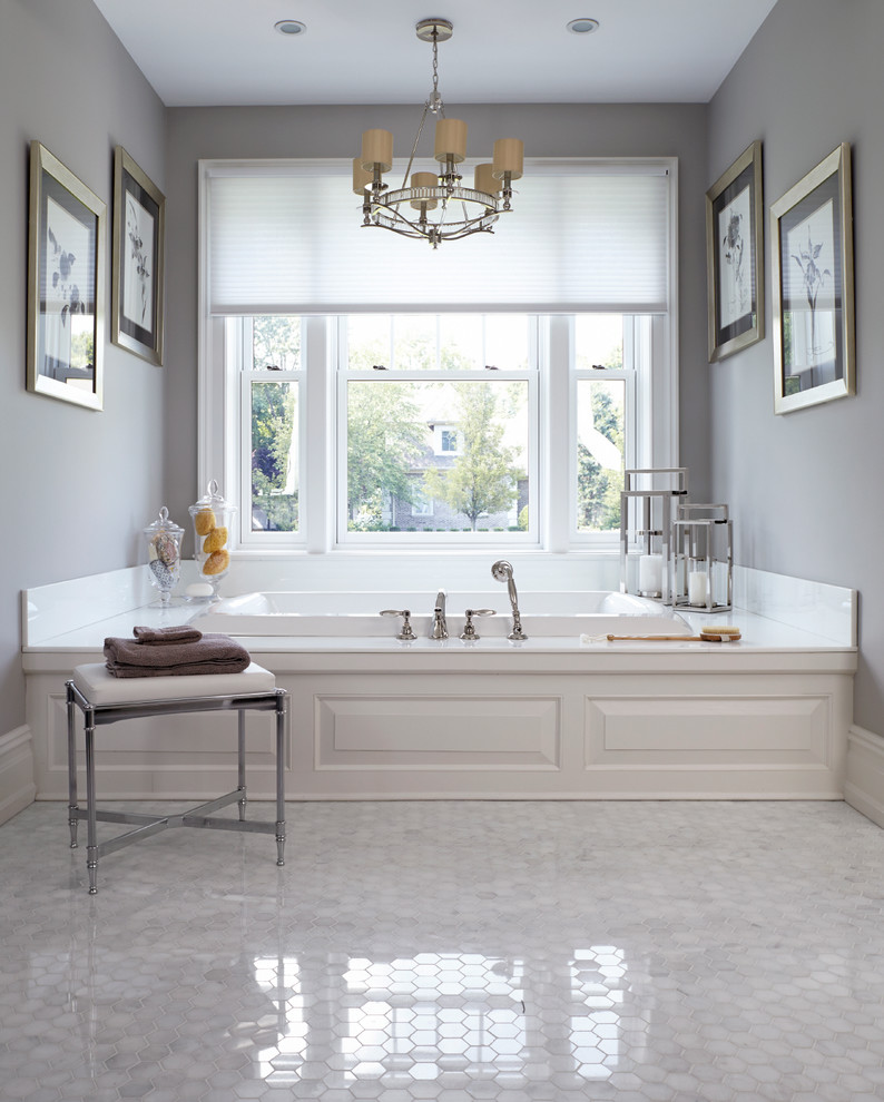 Inspiration for a large traditional master bathroom in New York with raised-panel cabinets, a drop-in tub and grey walls.