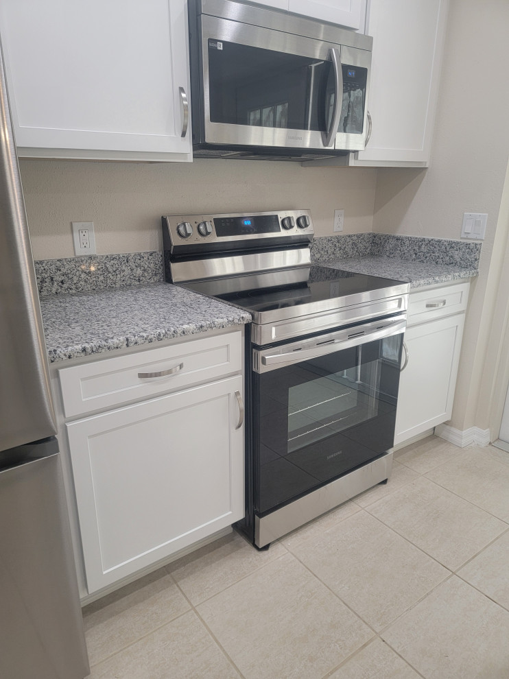 Inspiration for a mid-sized galley eat-in kitchen remodel with an undermount sink, shaker cabinets, white cabinets, quartz countertops, a peninsula and gray countertops