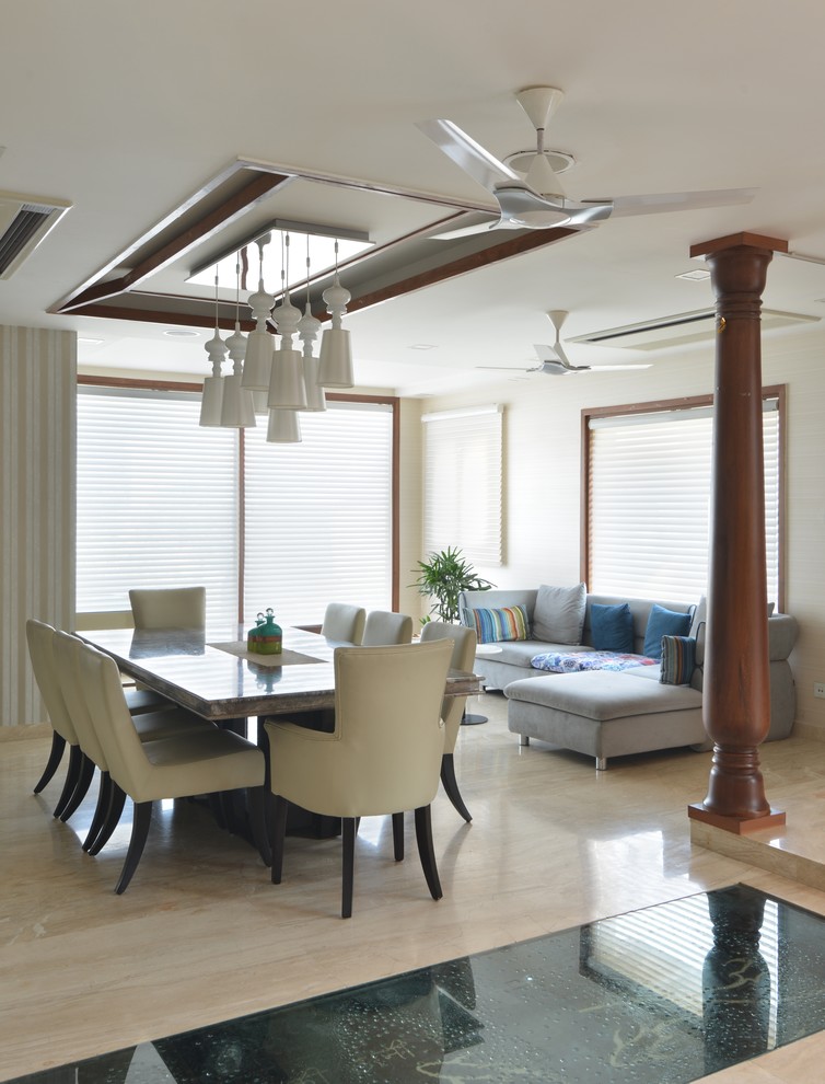 This is an example of a contemporary kitchen/dining combo in Delhi with white walls.
