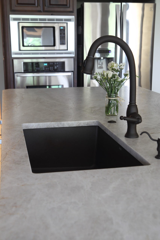 Enclosed kitchen - large transitional l-shaped ceramic tile and beige floor enclosed kitchen idea with an undermount sink, dark wood cabinets, beige backsplash, stainless steel appliances and an island