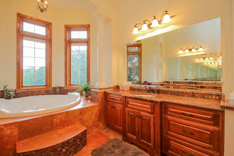 Design ideas for a large traditional master bathroom in DC Metro with an undermount sink, raised-panel cabinets, dark wood cabinets, granite benchtops, a drop-in tub, a double shower, a one-piece toilet, red tile, pebble tile, yellow walls and travertine floors.