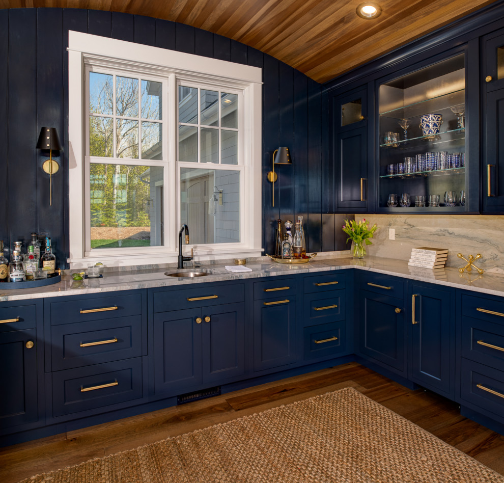 Beach style home bar in Other with blue cabinets.