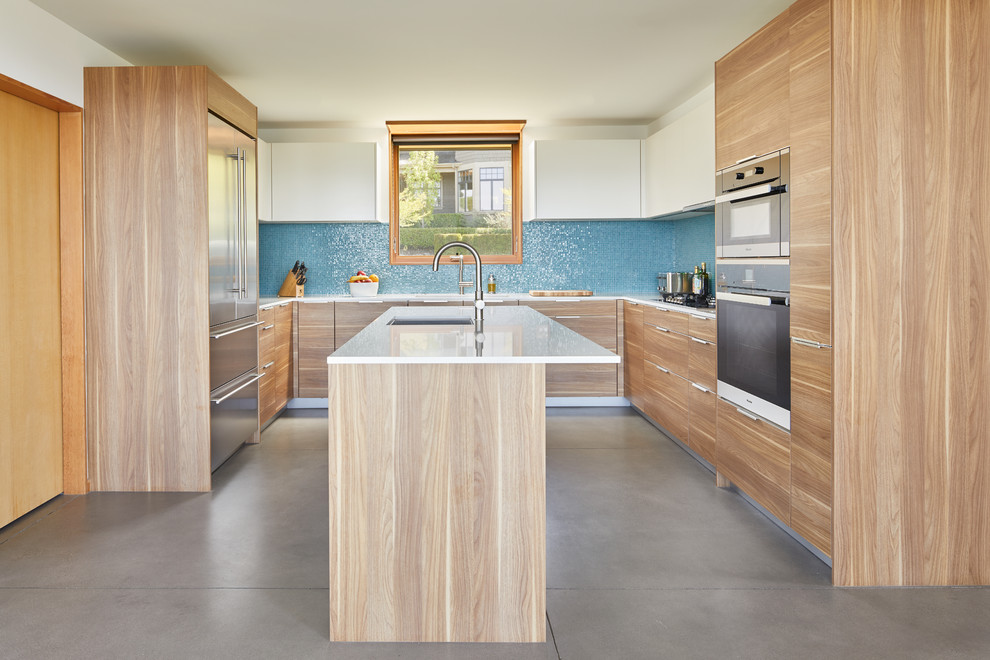 Design ideas for a contemporary u-shaped kitchen in Seattle with a single-bowl sink, flat-panel cabinets, medium wood cabinets, quartz benchtops, blue splashback, stainless steel appliances, concrete floors, with island, grey floor, white benchtop and mosaic tile splashback.