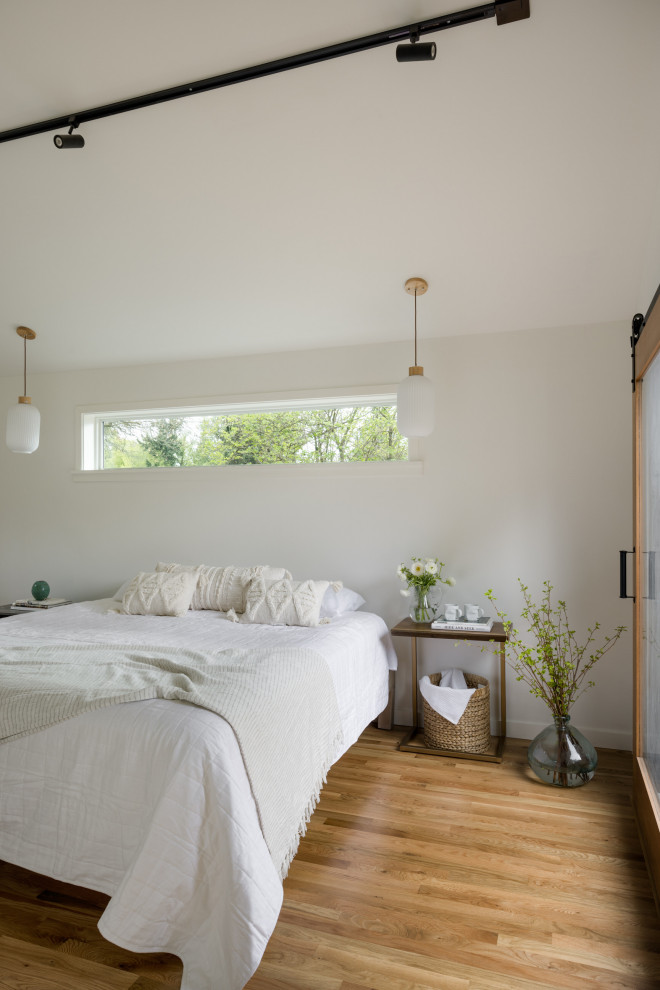 Idéer för ett litet modernt sovrum, med vita väggar och grått golv