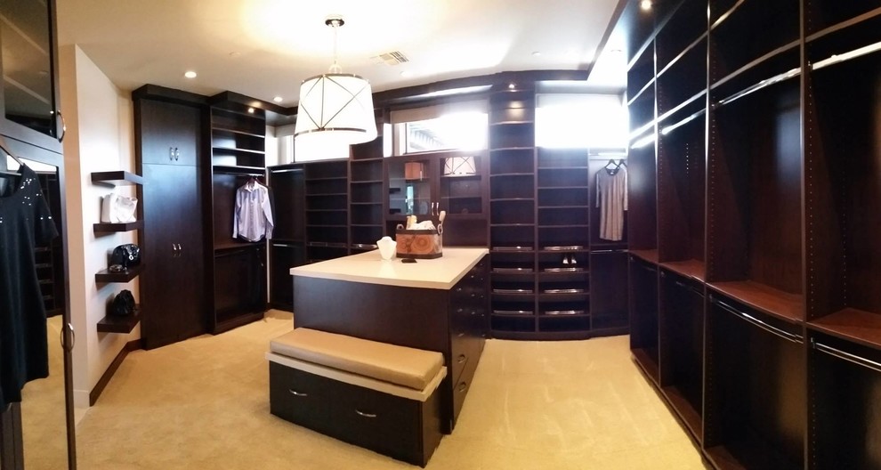 Inspiration for a mid-sized contemporary walk-in wardrobe in Las Vegas with flat-panel cabinets and dark wood cabinets.