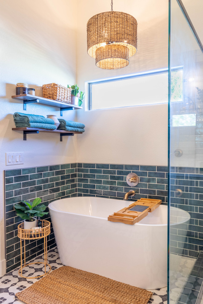 Aménagement d'une salle de bain principale rétro en bois clair de taille moyenne avec une baignoire indépendante, une douche ouverte, un carrelage vert, carreaux de ciment au sol, une cabine de douche à porte battante et meuble-lavabo encastré.