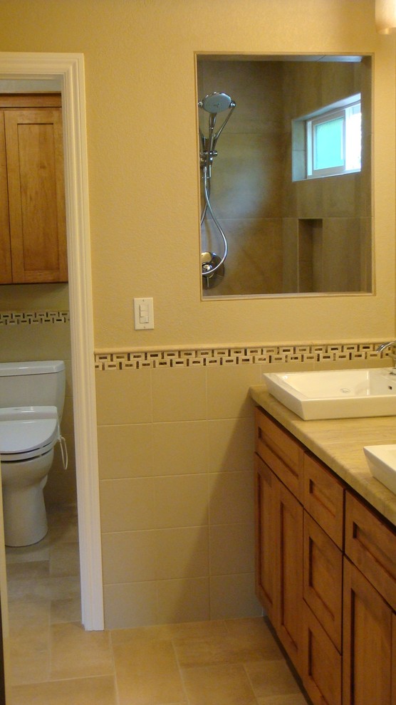 Photo of a mid-sized arts and crafts master bathroom in San Francisco with a vessel sink, shaker cabinets, medium wood cabinets, marble benchtops, an alcove shower, a two-piece toilet, multi-coloured tile, mosaic tile, yellow walls and porcelain floors.